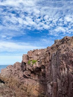 海岸にそびえる赤茶色の岩壁と青空の風景 岩,海岸,自然の写真素材