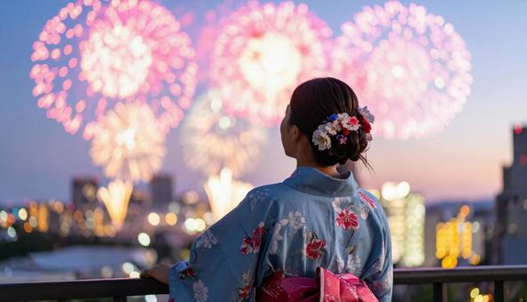 花火を見上げる浴衣姿の女性の後ろ姿 花火を見上げる浴衣姿の女性の後ろ姿の写真