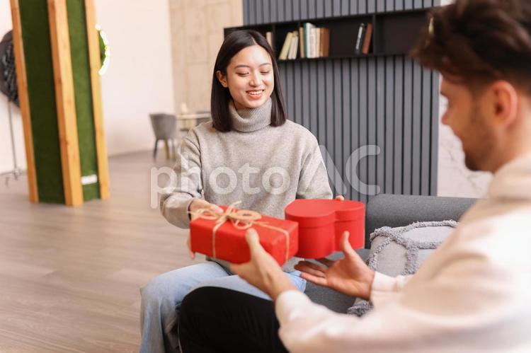 笑顔でプレゼントを交換するカップル バレンタイン,カップル,ポートレートの写真素材