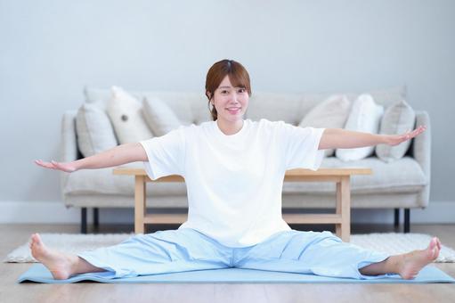 座って両手両足を広げ伸ばす笑顔の女性 女性,笑顔,ストレッチの写真素材
