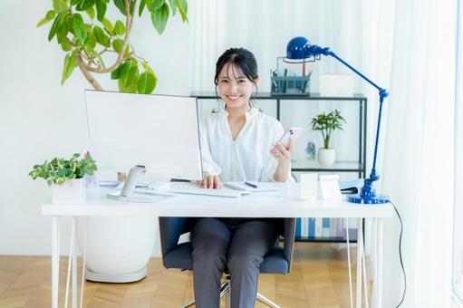 オフィスでスマホを持つビジネスウーマン スマホ,笑顔,ビジネスウーマンの写真素材