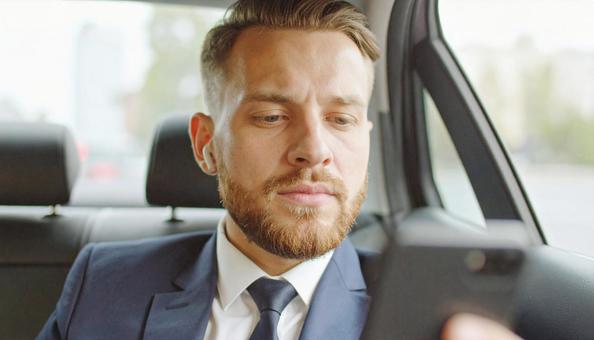 ワイヤレスイヤホンをつけて車に乗る男性 ワイヤレスイヤホンをつけて車に乗る男性の写真