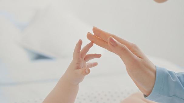 大人の手に触ろうと手を伸ばす赤ちゃんの手 大人の手に触ろうと手を伸ばす赤ちゃんの手 手,指,手元の写真素材