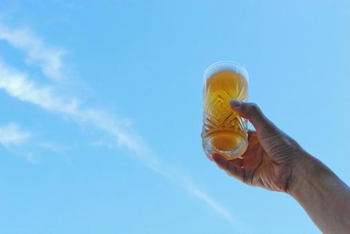 ビールグラスを持つ男性の手右寄せ ビールグラスを持つ男性の手右寄せ 青空,ビール,夏の写真素材