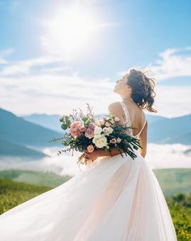 丘を歩くウェディングドレス姿の女性	の写真