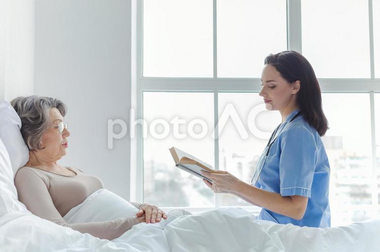 読み聞かせする女医と患者 女性,女医,患者の写真素材