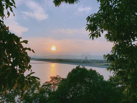 湖畔に沈む夕日と観覧車のシルエット 湖畔に沈む夕日と観覧車のシルエット 夕日,湖,観覧車の写真素材