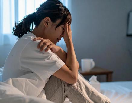 部屋でうつ病・体調不良に悩む日本人女性 部屋でうつ病・体調不良に悩む日本人女性の写真