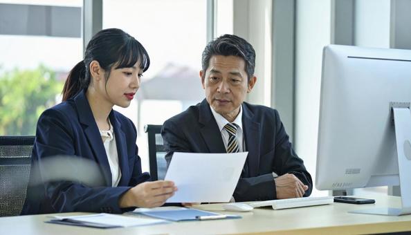 上司にデータを説明する女性社員 上司にデータを説明する女性社員の写真