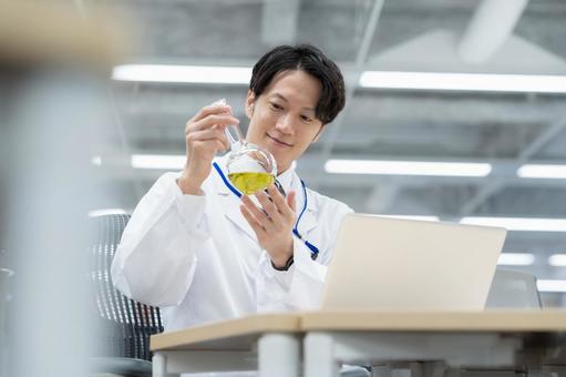 実験をする白衣の若い男性研究者 実験をする白衣の若い男性研究者 研究,実験,サイエンスの写真素材