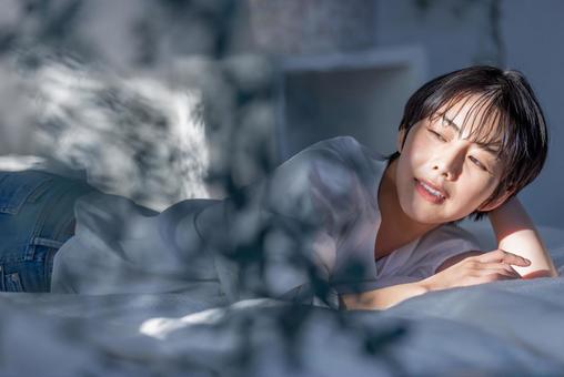うつ伏せでくつろぐ女性 うつ伏せでくつろぐ女性 女性,人物,寝るの写真素材