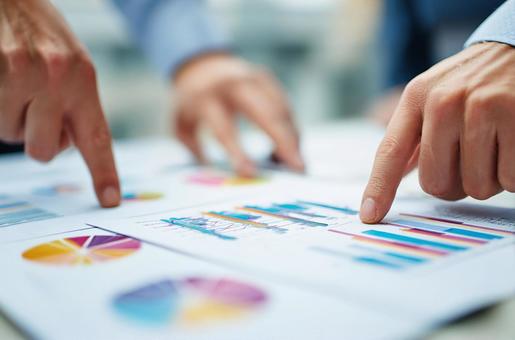 会議でグラフや書類を共有するシーンの写真