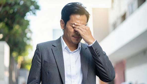 ビジネスイメージ　うつむき悩む男性の写真