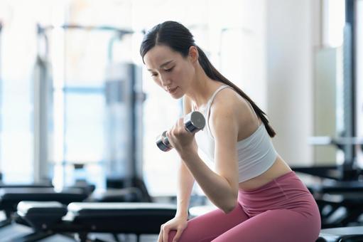 スポーツジムでトレーニングをする若い女性 スポーツジム,フィットネス,ダイエットの写真素材