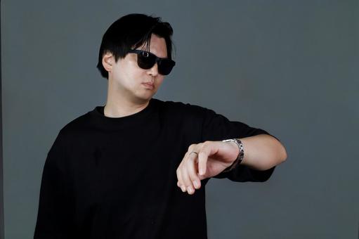 腕時計を確認する男性 腕時計を確認する男性 男性,腕時計,黒い服の写真素材