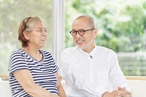 Elderly couple sitting on the couch and having a conversation, ältere menschen, paar, ein lächeln, JPG