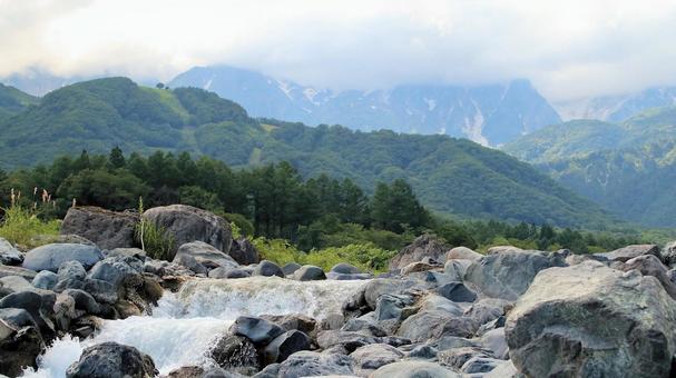 夏の白馬の山々と雪解け水が流れる松川 夏の白馬の山々と雪解け水が流れる松川の写真