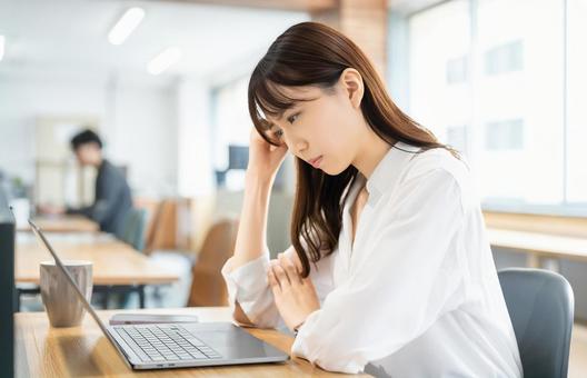 パソコンを使いながら考える女性 パソコンを使いながら考える女性 女性,パソコン,考えるの写真素材