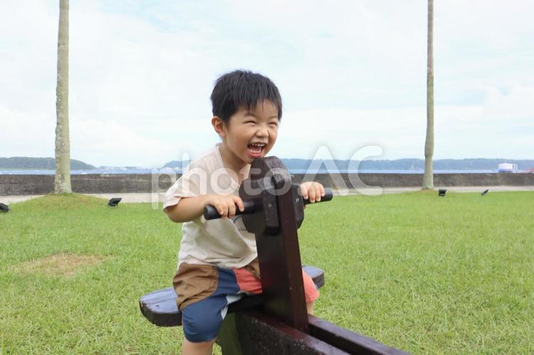 シーソーに乗って笑う3歳の男の子 男の子,子供,笑顔の写真素材
