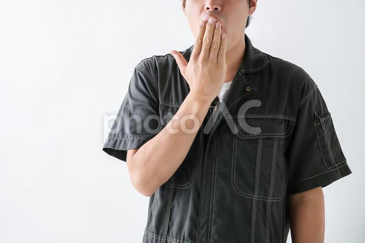 口をおさえる作業着の男性 1人,30代,40代の写真素材