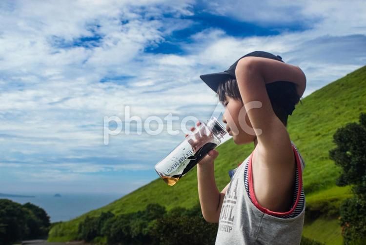 ＜素材＞公園遊び中に水筒のお茶を飲む少年 子供,青空,飲むの写真素材