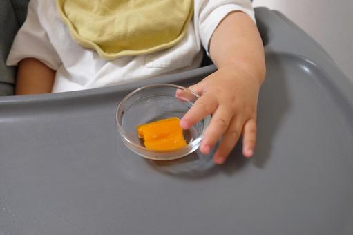 手づかみでにんじんを食べようとする子ども 手づかみでにんじんを食べようとする子どもの写真