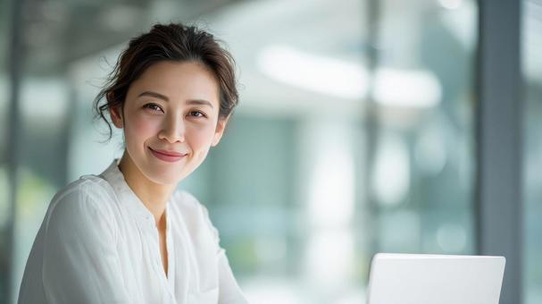 オフィスで微笑む女性会社員 オフィスで微笑む女性会社員の写真