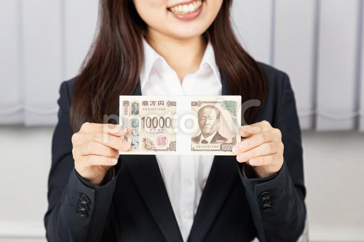 100万円を持つスーツ姿の女性の手元02 女性,手元,お金の写真素材