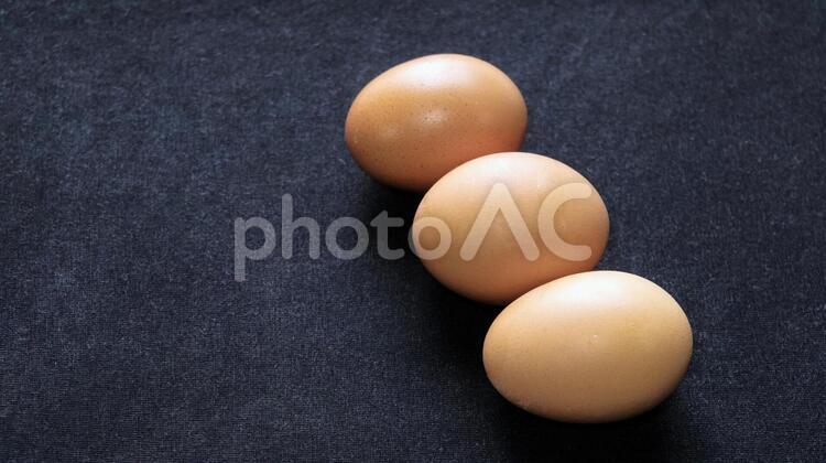 黒バックに赤玉の卵３つ 卵,赤玉,３の写真素材