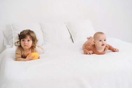 ベッドの上の2人の子供 赤ちゃん,かわいい,ベッドの写真素材