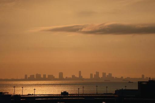 オレンジ色の空と海とシルエットのビル群 オレンジ色,空,海の写真素材