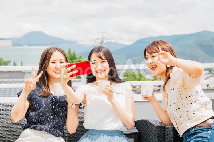 屋上でパーティーをする女性たち（自撮り） 女子会,自撮り,スマホの写真素材