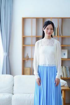 カメラ目線で立つ青いスカートの女性 女性,微笑む,立つの写真素材