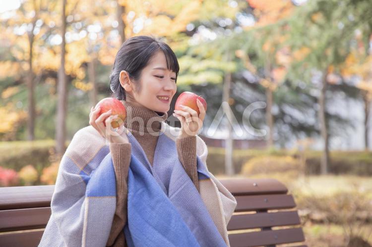 秋の公園でりんごを食べる女性 りんご,秋,女性の写真素材