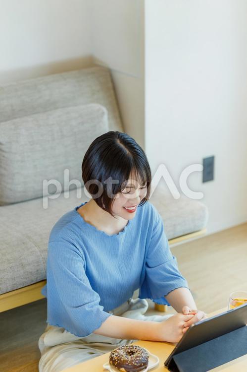 おやつを食べながらリモート通話をする女性 女性,リビング,リモートワークの写真素材