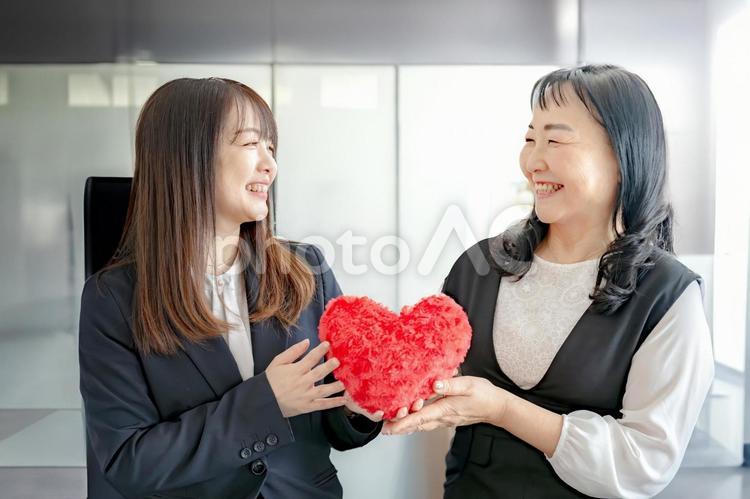 ハートを渡すビジネスウーマン 女性,笑顔,ビジネスウーマンの写真素材
