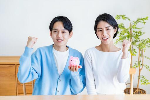 豚の貯金箱を持つカップル 貯金,貯蓄,節約の写真素材