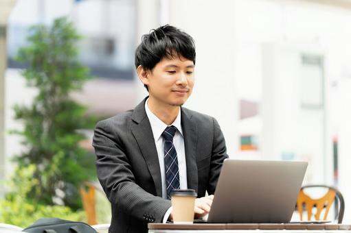 テラス席でパソコンを使う男性ビジネスマン テラス席でパソコンを使う男性ビジネスマン 男性,パソコン,ノートパソコンの写真素材