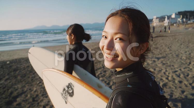 海辺の砂浜でサーフボードを抱え歩く女性 夏,海辺,サーフィンの写真素材
