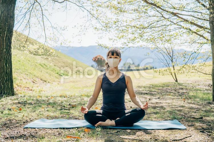 屋外でヨガをする女性（座位） ヨガ,マスク,ダイエットの写真素材