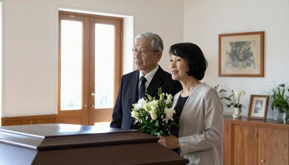 棺を見つめるミドルの男女の写真