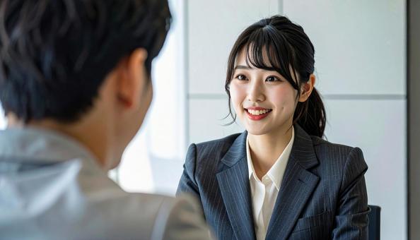 笑顔で話すスーツ姿の女性の写真