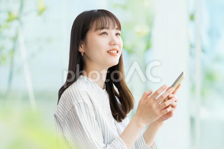 スマホを使う笑顔の女性・ビジネスウーマン 女性,スマホ,笑顔の写真素材