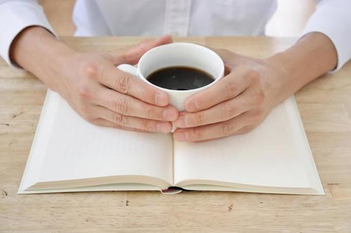 コーヒーを飲みながら本を読む男性 コーヒーを飲みながら本を読む男性の写真