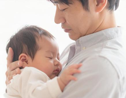 赤ちゃんを抱っこする父親 赤ちゃんを抱っこする父親の写真