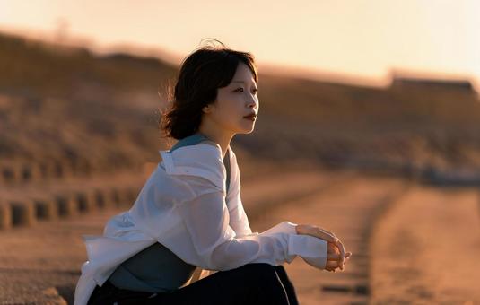 夏の夕暮れにたたずむ女性 夏の夕暮れにたたずむ女性 夏,夕日,夕方の写真素材