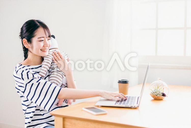 赤ちゃんを抱きながらテレワークする女性 赤ちゃん,保育,世話の写真素材