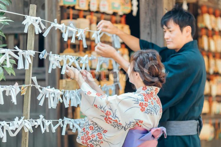 おみくじを結ぶ浴衣姿の男女 おみくじ,願い事,運勢の写真素材
