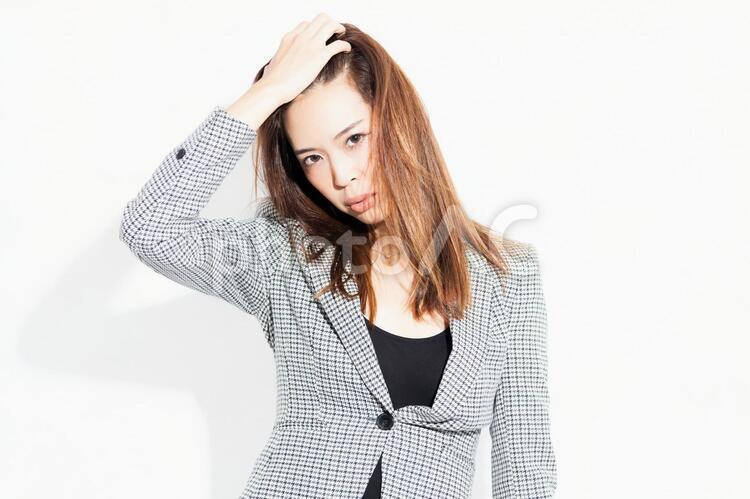 白い背景の前に立ってポーズをとる若いビジネスウーマン 女性,白背景,立つの写真素材