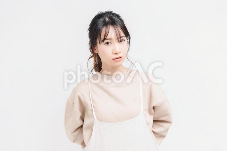 白い背景の前に立ってポーズをとる若い女性 女性,白背景,立つの写真素材